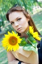 Thoughtful young woman in black dress holding sunflowers Royalty Free Stock Photo