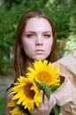 Thoughtful young woman in black dress holding sunflowers Royalty Free Stock Photo