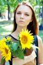 Thoughtful young woman in black dress holding sunflowers Royalty Free Stock Photo