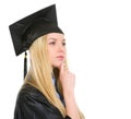 Thoughtful young woman in graduation gown Royalty Free Stock Photo
