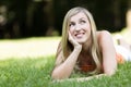 Thoughtful young woman lying on the grass Royalty Free Stock Photo