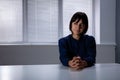 Thoughtful Young Woman Sitting Alone At Desk