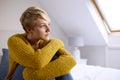 Thoughtful Young Woman Sitting On Bed At Home Looking Out Of Window Royalty Free Stock Photo