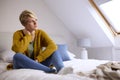 Thoughtful Young Woman Sitting On Bed At Home Looking Out Of Window Royalty Free Stock Photo