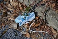 Thoughtlessly thrown away protective mask against SARS-Covid-19, which is lying on the ground as garbage by the roadside