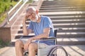 A disabled man in a wheel chair outdoors looking thoughtful Royalty Free Stock Photo