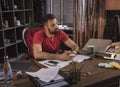 Business man sitting in chair at wooden table with tablet smartphone and laptop