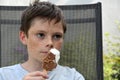Thoughts lost boy with many freckles eats a popsicle Royalty Free Stock Photo