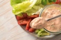 Thousand Island sauce based on skyr on a spoon and in a glass jar over slices of lettuce and tomato salad, healthy raw food meal, Royalty Free Stock Photo