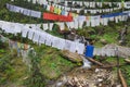 Thousands of colorful and white prayer flags are hoisted over the roadside waterfall in Thimphu-Paro Highway