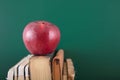 A thread-bound book and a red apple on the book in front of the blackboard Royalty Free Stock Photo