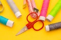 Thread, needles, scissors and meter on yellow background. tailoring set. sewing kit multi-colored. Royalty Free Stock Photo