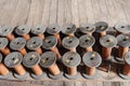 Thread and silk spools sit empty on a wooden floor of an old ab