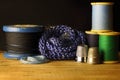 THREAD ON SPOOLS INCLUDING WOODEN VINTAGE REEL WITH BLACK THREAD AND THIMBLES Royalty Free Stock Photo