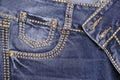 Thread-stitched front pocket of blue fashion jeans with studs Royalty Free Stock Photo