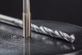 Thread tap drill steel billet with drill bit on background. Working cutter