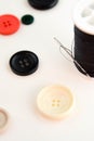 Threaded needle, black thread spool and buttons Royalty Free Stock Photo