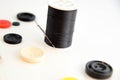 Threaded needle, black thread spool and buttons Royalty Free Stock Photo