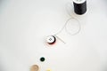 Threaded needle, buttons, and black spool of thread Royalty Free Stock Photo