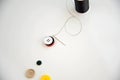 Threaded needle, buttons, and black spool of thread Royalty Free Stock Photo