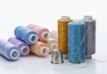 Threads of different colors for needlework. Thimble and needle.