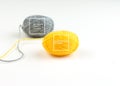 Threads for knitting fashionable sweaters. Yellow and gray ball of woolen thread on a white background. Illuminating and