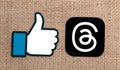 Threads mobile app icon and Facebook Like logo on sackcloth textile background close-up. Meta Officially Launches Royalty Free Stock Photo