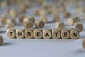 Threaten - cube with letters, sign with wooden cubes