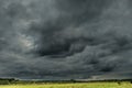 Threatening dark rain clouds over a vast plain.