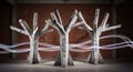 Three abstract concrete trees with light streaks in an industrial brick building setting Royalty Free Stock Photo