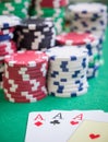 Three aces and red cubes with poker chips on green table Royalty Free Stock Photo