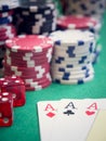 Three aces and red cubes with poker chips on green table Royalty Free Stock Photo