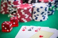 Three aces and red cubes with poker chips on green table Royalty Free Stock Photo