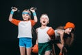 Three active kids in sportswear posing with sport equipment