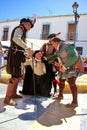 Three actors in medieval costumes act out a theatrical scene