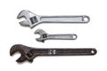 Two chrome-plated adjustable wrenches and one rusted on white Royalty Free Stock Photo