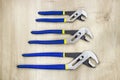 Three adjustable wrenches on wood background