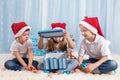 Three adorable kids, preschool children, siblings, having fun for Christmas, opening box with decoration Royalty Free Stock Photo