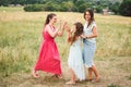 Three adult Caucasian sisters are playing and having fun on the field. A family of three young women laugh and spend summer time