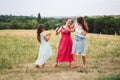 Three adult Caucasian sisters are playing and having fun on the field. A family of three young women laugh and spend summer time