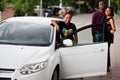 Three african american friends stay near car.