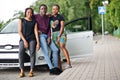 Three african american friends stay near car.