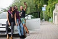 Three african american friends stay near car.