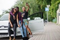 Three african american friends stay near car.