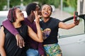 Three african american friends stay near car.