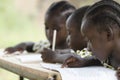 Three African children learning at school outdoors