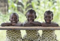 Three African children sitting outdoors smiling and laughing Royalty Free Stock Photo