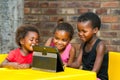 Three african kids playing together on tablet. Royalty Free Stock Photo