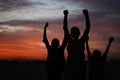 Three African Siblings Raising Their Hands Against A Colorful Evening Sky Royalty Free Stock Photo