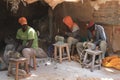 Three African young men working at a souvenir factory in the poorest district of Nairobi - Kibera are sitting on chairs and workin